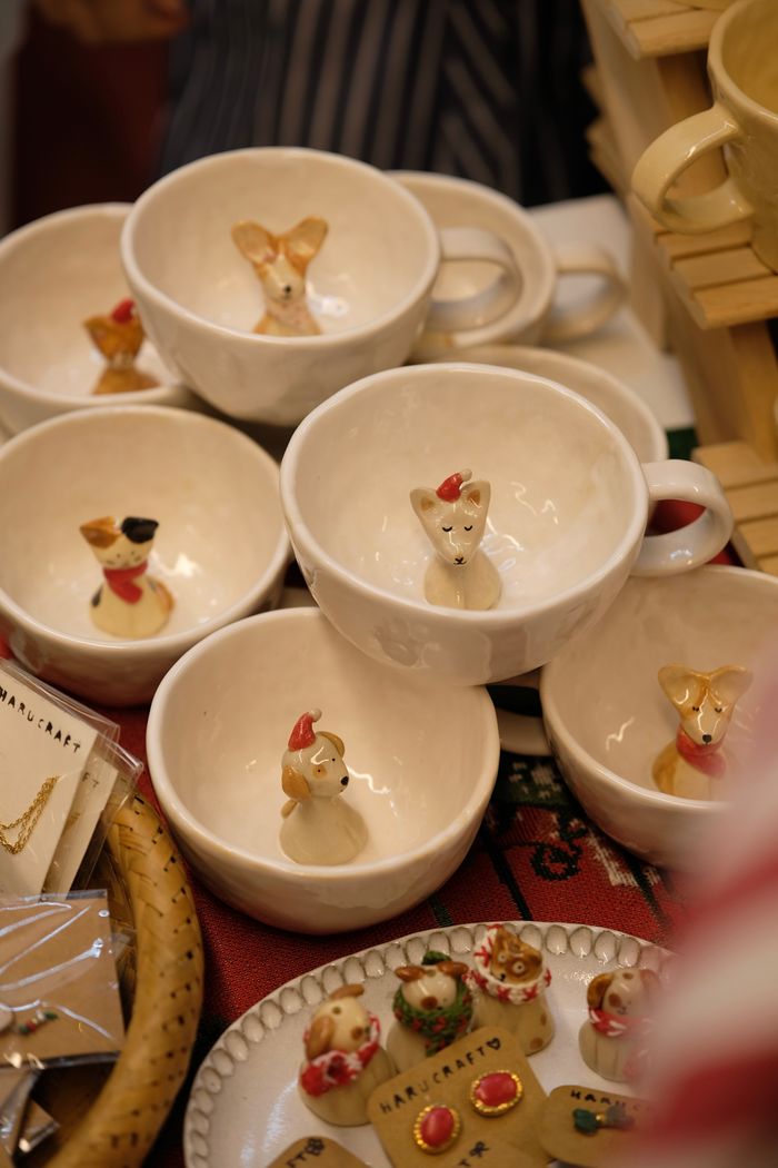 about-01 Ceramic mugs with animal designs displayed on a market table, perfect for unique kitchenware enthusiasts.
