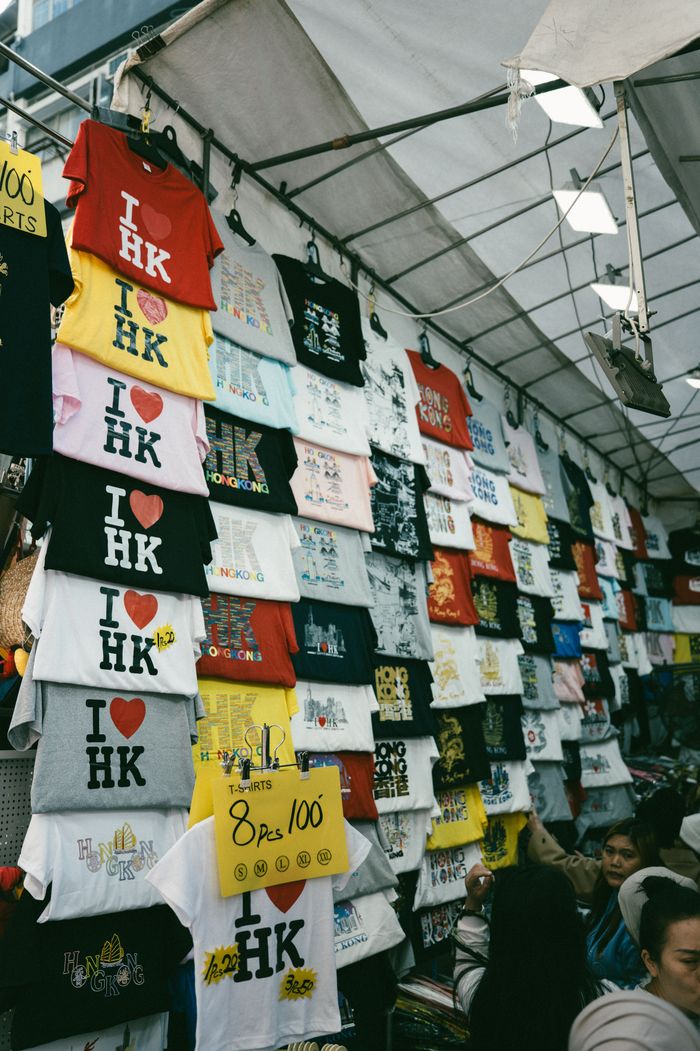 hero-img-02 Vibrant street market scene featuring I love HK t-shirts, ideal for travel or Hong Kong-themed content.